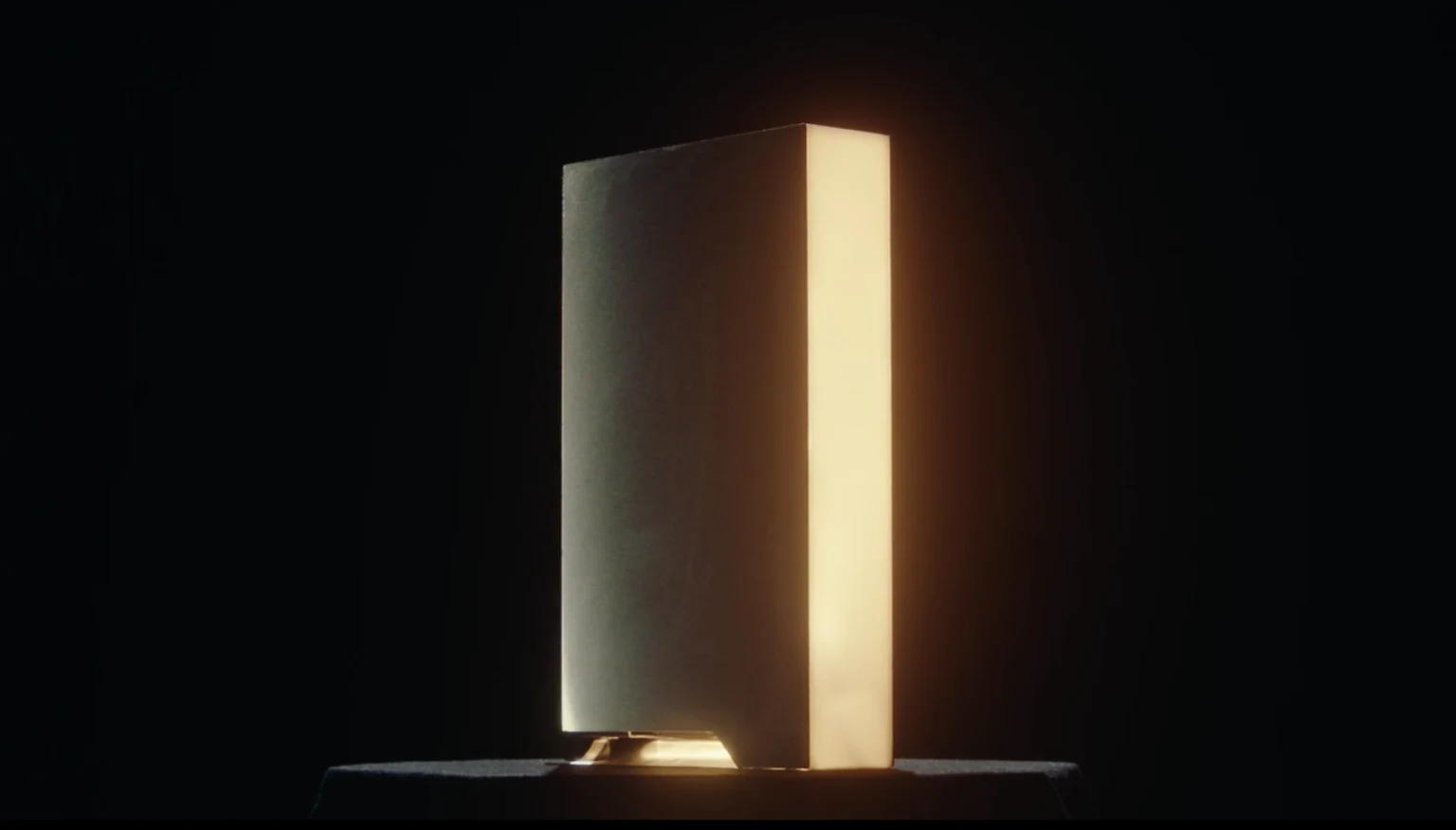 A tall rectangular computer tower glows along one side against a dark background.